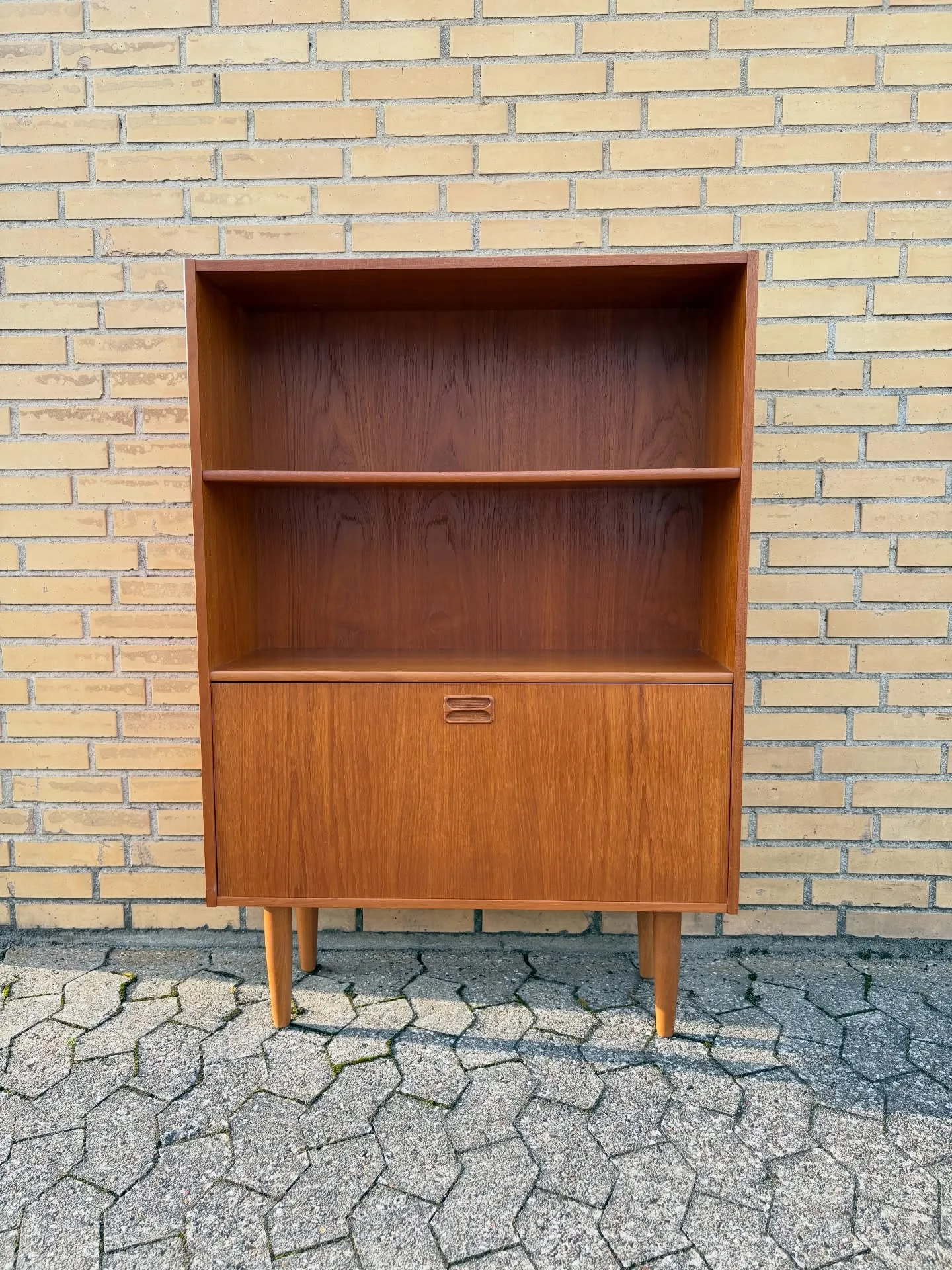 Teak reol.

Hylder, låge hvor bag indeling og hylde. Monteret på runde tilspidsede ben. D…